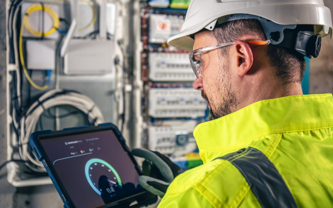Technicien vérifiant un tableau électrique pour optimiser la consommation de chauffage industriel