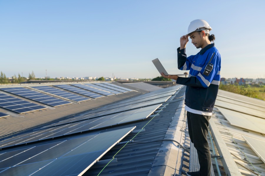 Technicien installant une toiture solaire hybride sur un bâtiment existant